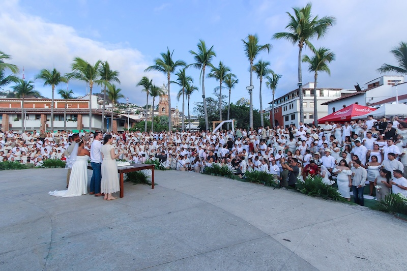 303 couples of all genders were wed on the afternoon of Friday, March 27, 2026, at Los Arcos del Malecón. Part of the 2026 Collective Marriage campaign organized by the Puerto Vallarta Civil Registry, the event set a new record for the municipality. The couples shared a sunset ceremony witnessed by family, friends, and the community.